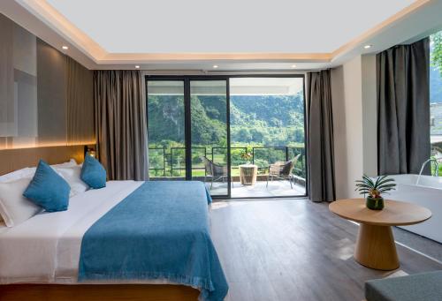 a hotel room with a bed and a balcony at Yangshuo-Greenery Retreat in Yangshuo