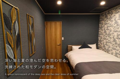 a bedroom with a bed and a wooden door at 金鱗湖まで徒歩2分 湯布院 天然温泉ヴィラ 響 -hibiki- in Yufu