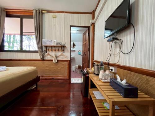 a bedroom with a bed and a television and a table at ทิพย์วาริน รีสอร์ท เขาใหญ่ in Ban Tha Chang