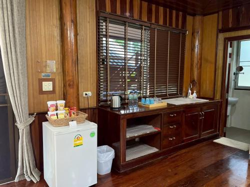a kitchen with a sink and a refrigerator at ทิพย์วาริน รีสอร์ท เขาใหญ่ in Ban Tha Chang