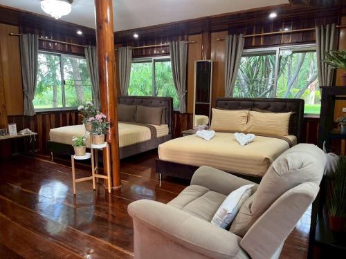 a living room with two beds and a couch at ทิพย์วาริน รีสอร์ท เขาใหญ่ in Ban Tha Chang