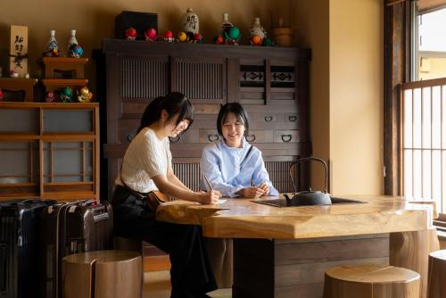 two women sitting at a table in a room at Onyado Yuinosho, Shirakawago in Shirakawa