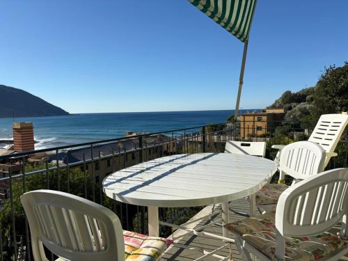 a white table and chairs on a balcony with the ocean at Il terrazzino sul Golfo in Recco