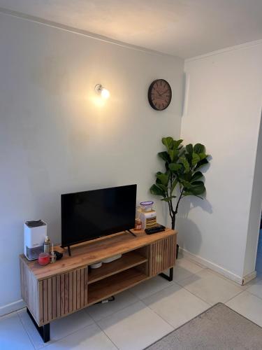 a flat screen tv sitting on top of a wooden entertainment center at Two-room apartment in Villiers-le-Bel