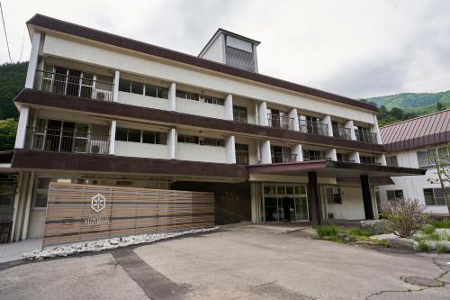a large building with a gate in front of it at Shima Onsen Yuzuriha in Nakanojo