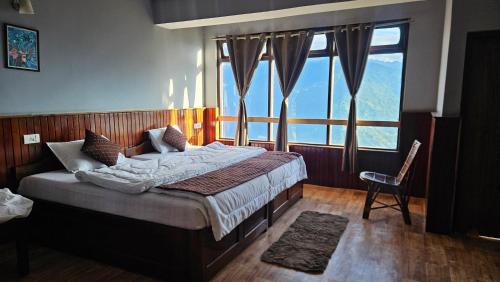 una camera da letto con un letto e una grande finestra di Sikkimese Inn Pelling a Pelling