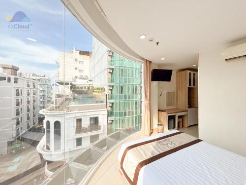 a bedroom with a bed and a large window at Bella VT Hotel - Bãi Sau Vũng Tàu in Vung Tau