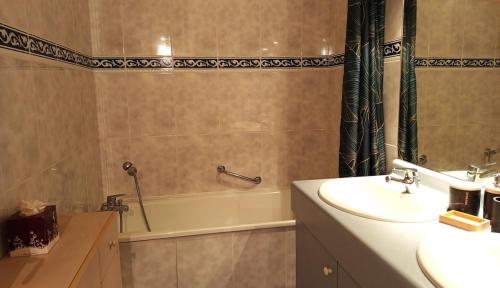 a bathroom with a tub and a sink and a bath tub at Appartement plein centre à 300m de la plage in Le Touquet-Paris-Plage