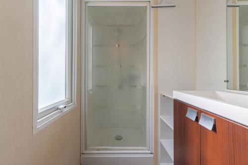 a bathroom with a shower and a white sink at Mobil-home in La Roque-dʼAnthéron