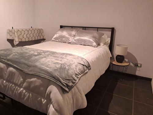 a bedroom with a bed and a lamp on a tiled floor at Costa Verde Retreat 1 - Ground Floor in Quepos
