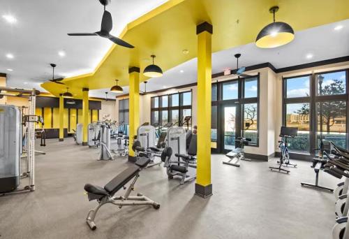 a gym with several treadmills and elliptical machines at Central Frisco Vibes 1 BR Apart With POOL & GYM in Frisco