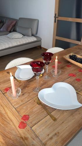 a wooden table with wine glasses and candles on it at Cottage de pénélope in Lunéville