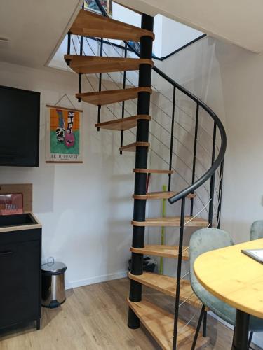 a spiral staircase in a room with a table at PopLaon appartement avec terrasse in Laon