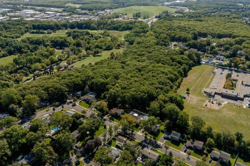 an aerial view of a park with trees and buildings at Luxury 6BR House with Pool & Outdoor BBQ in Plainview