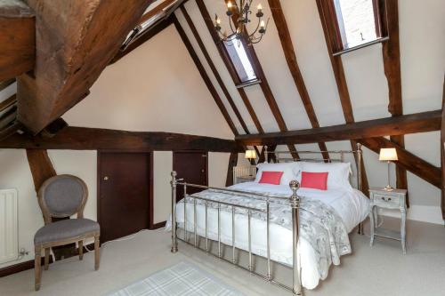 1 dormitorio en el ático con 1 cama y 1 silla en 12A College Hill by Sleep Shrewsbury, en Shrewsbury