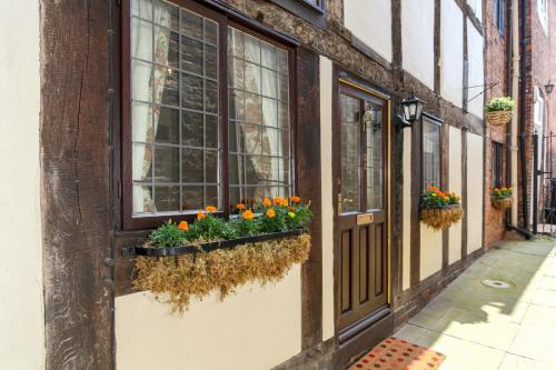 a street with flowers in window boxes on a building at 12A College Hill by Sleep Shrewsbury in Shrewsbury