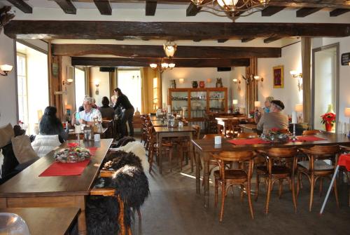 a group of people sitting at tables in a restaurant at Kasteel Schaloen in Valkenburg