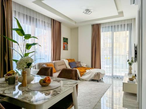 a living room with a couch and a table at Qoople Aria premium apartments in the center of Alanya in Alanya
