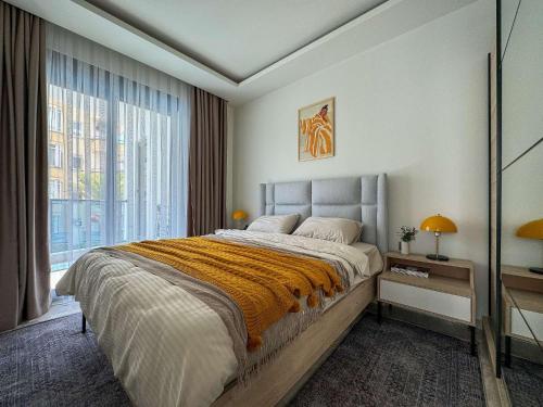 a bedroom with a large bed and a large window at Qoople Aria premium apartments in the center of Alanya in Alanya