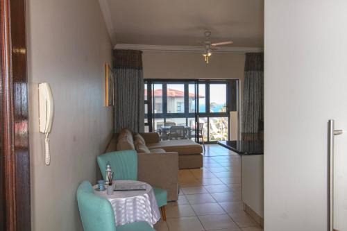 a living room with a couch and a table at Topanga 52 in Uvongo Beach