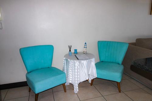 two chairs and a table in a living room at Topanga 52 in Uvongo Beach