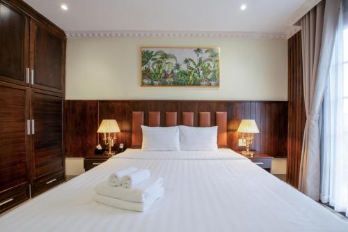 a bedroom with a large white bed with two towels at Linh's Boutique Hotel in Phu Quoc