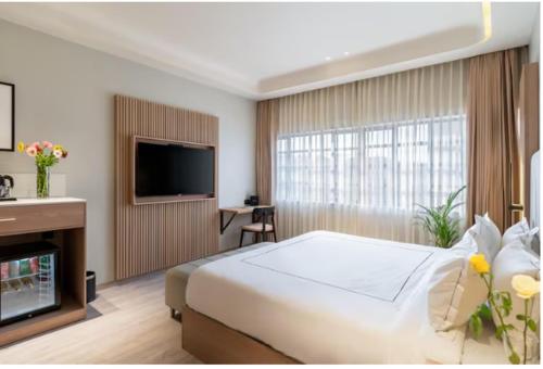 a hotel room with a bed and a television at Champion Prime-My Downtown Hotel in Udaipur