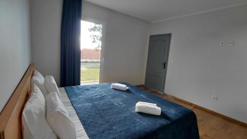 a bedroom with a bed with two towels on it at Oak Tree House- Ponta do Pargo in Lombada Velha