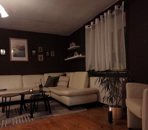 a living room with a white couch and a table at Pension - Ferienwohnung K&M in Nünchritz