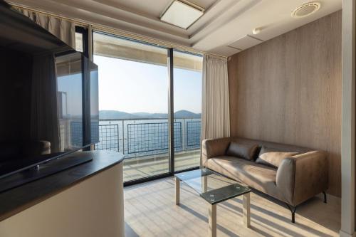 a living room with a couch and a large window at Moji HOTEL HARBOR LIGHT in Kitakyushu