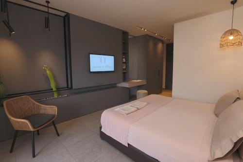 a bedroom with a bed and a chair and a tv at OCEAN BLUE HOTEL & RESORT -Jbeil in Jbeil
