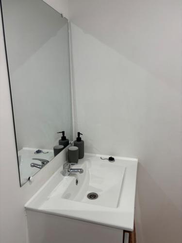 un bagno con un lavandino bianco e uno specchio di Marcory, proche aéroport a Tillé