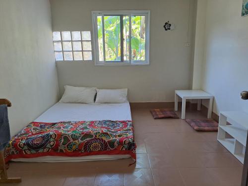 a small bedroom with a bed and a window at WAKE UP @Lanta Hotel : Cafe in Ko Lanta