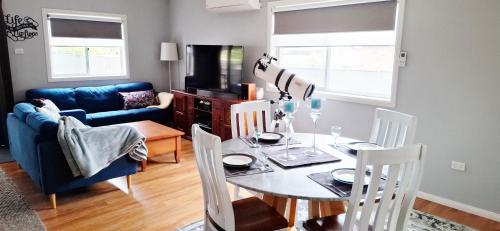 a living room with a table and a blue couch at Flipflops in Culburra Beach