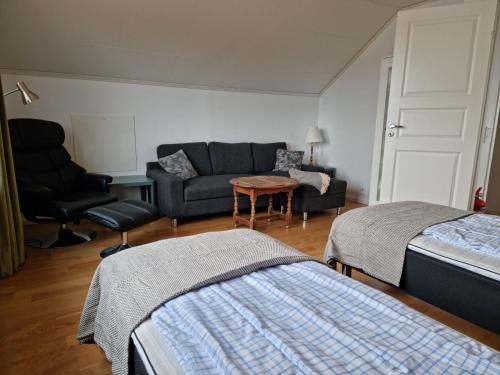 a living room with two beds and a couch at Panoramic view on Ellos top with 500m to sea in Ellös