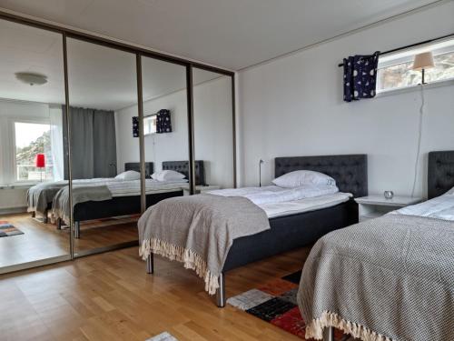 a bedroom with two beds and a large mirror at Panoramic view on Ellos top with 500m to sea in Ellös