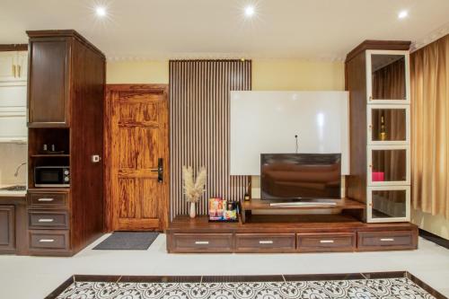 a living room with a tv and a wooden door at Linh's Boutique Hotel in Phu Quoc