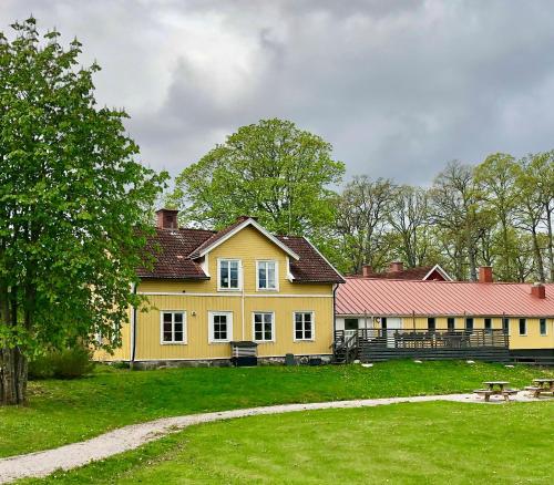 a large yellow house with a red roof at Gula Villan apartment in Västervik
