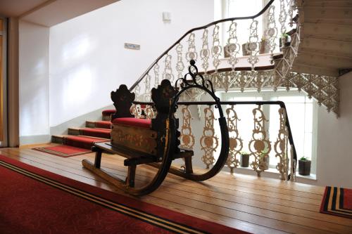 a stairway with a red carpet and a spiral staircase at Sporthotel Pontresina in Pontresina