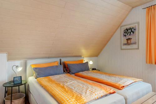バート・クロツィンゲンにあるFerienwohnung 2 Haus Schmiedewegのベッドルーム1室(オレンジと青の枕が備わるベッド2台付)