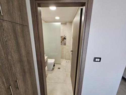 Un baño con una puerta que da a un inodoro. en Elounda Sunrise Apartments, en Elounda