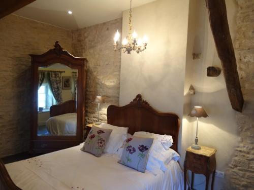 ムルソーにあるLa Petite Maisonのベッドルーム1室(白いシーツと鏡付きのベッド1台付)