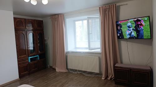 a living room with a tv and a window at Family and friends apartment in Ternopilʼ