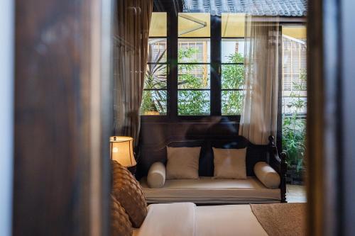 a bed in a room with windows and a couch at Floral Sheqinghe B&B in Lijiang