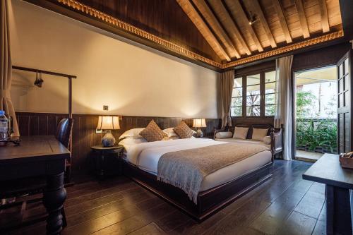 a bedroom with a large bed and a desk at Floral Sheqinghe B&B in Lijiang