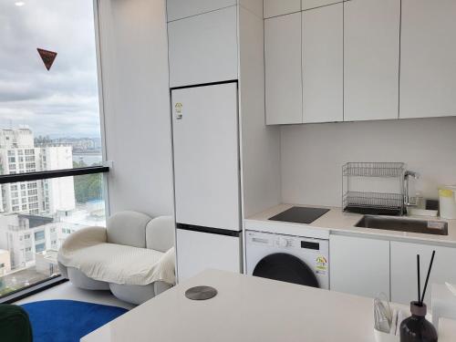 ソウルにあるSun&Uの白いキャビネットと椅子と食器洗い機を備えたキッチン