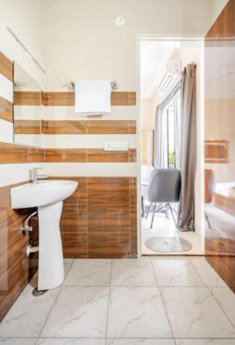 a bathroom with a sink and a chair in a room at The Royal Harmony in Greater Noida