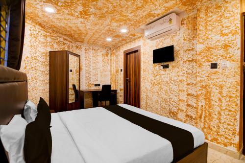 a bedroom with a bed and a desk in a room at Townhouse Oak Moulali Bus Terminal Formerly Creek Row in Kolkata