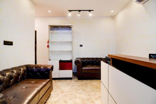 a living room with two leather chairs and a couch at Townhouse Oak Moulali Bus Terminal Formerly Creek Row in Kolkata