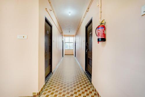 a hallway with a tile floor and a fire extinguisher at Hotel O Karanodai Formely AVR Rooms 